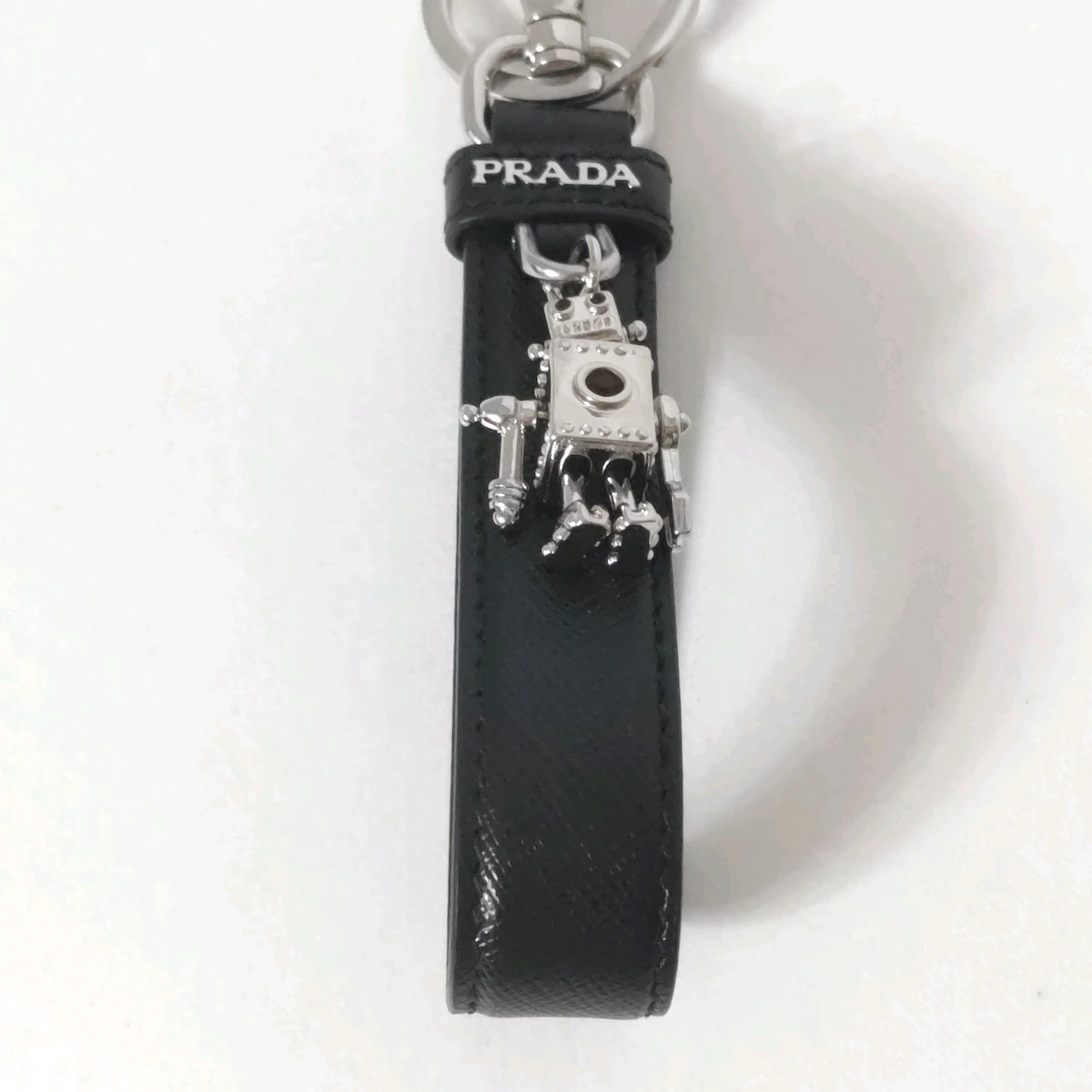 PRADA - Charm para bolso de piel negra, plateada y roja con herrajes de pedrería