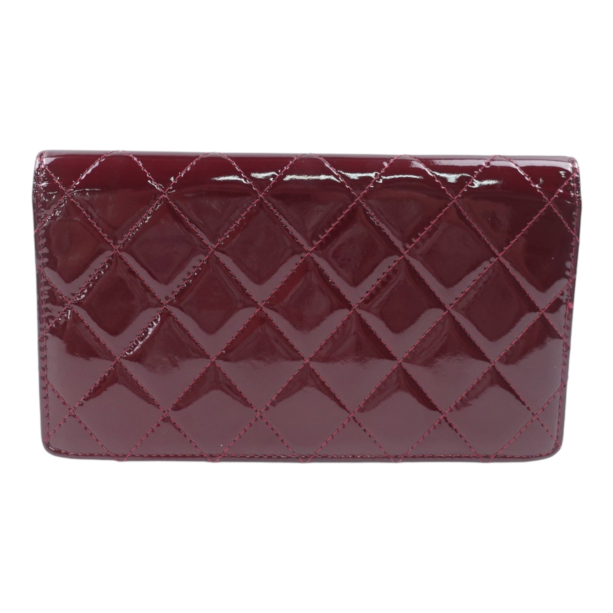 Cartera CC acolchada con yenes brillantes en color burdeos de charol, de segunda mano