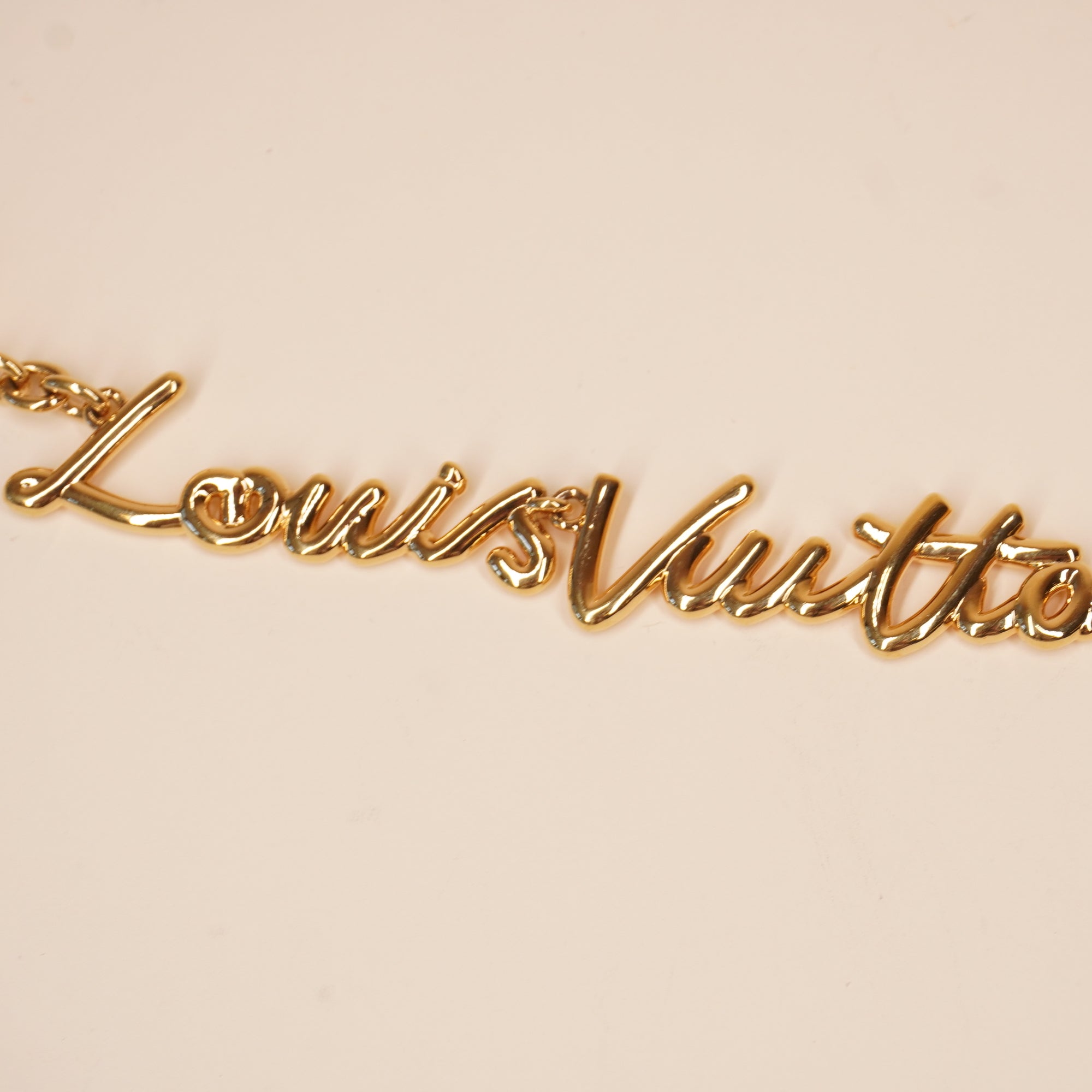 PRE-OWNED Metal LV Script Chain Bag Charm Gold Tone