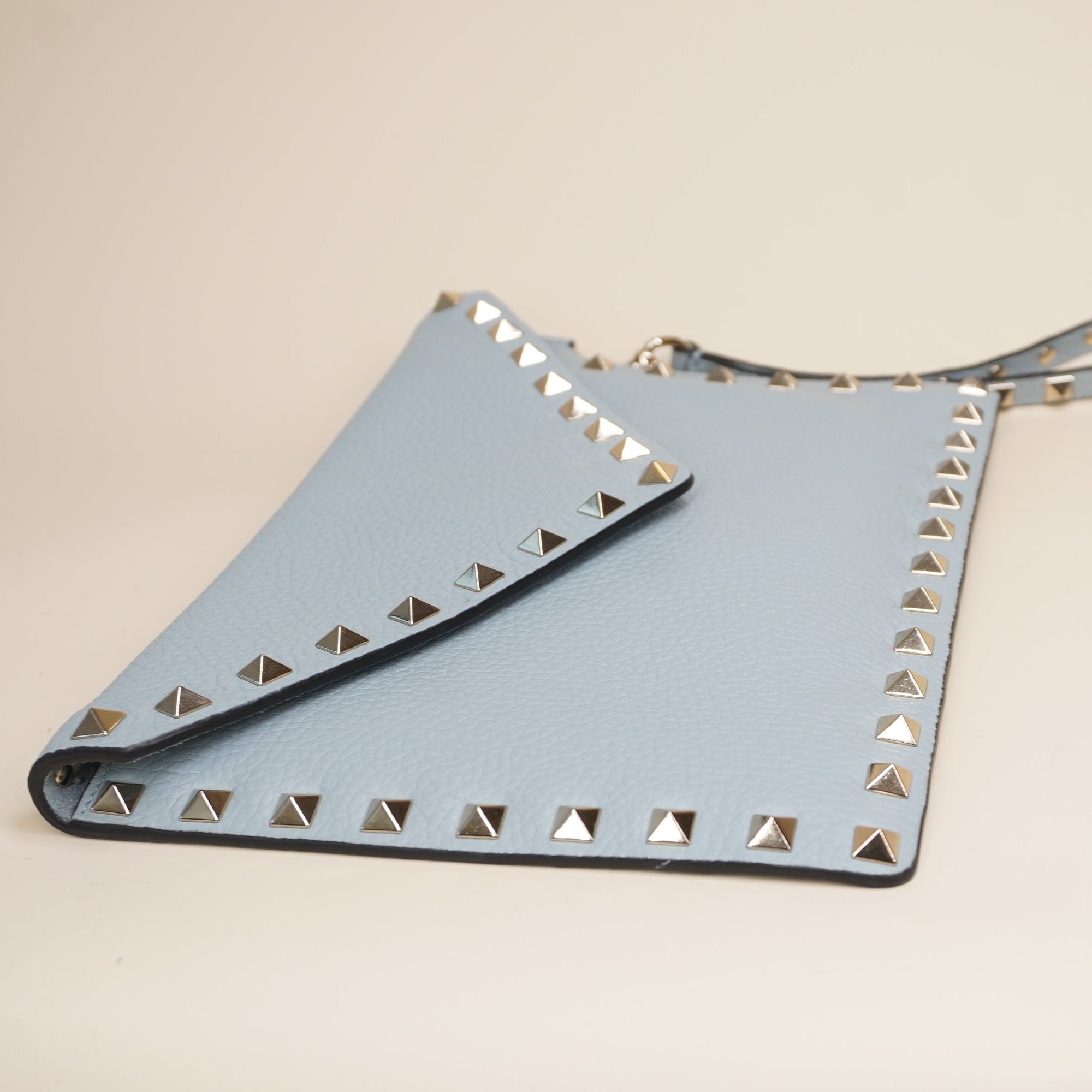 PRE-OWNED Light Blue Rockstud Grainy Calfskin Pouch