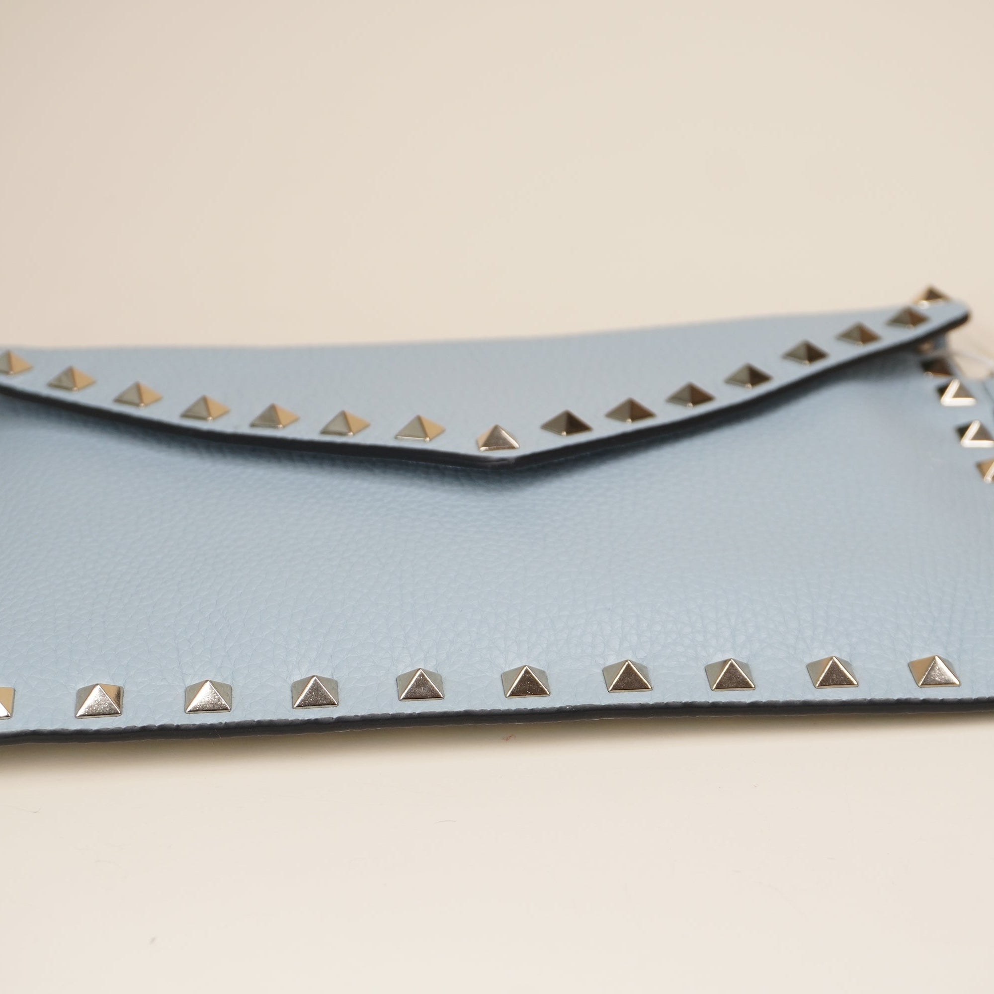 PRE-OWNED Light Blue Rockstud Grainy Calfskin Pouch