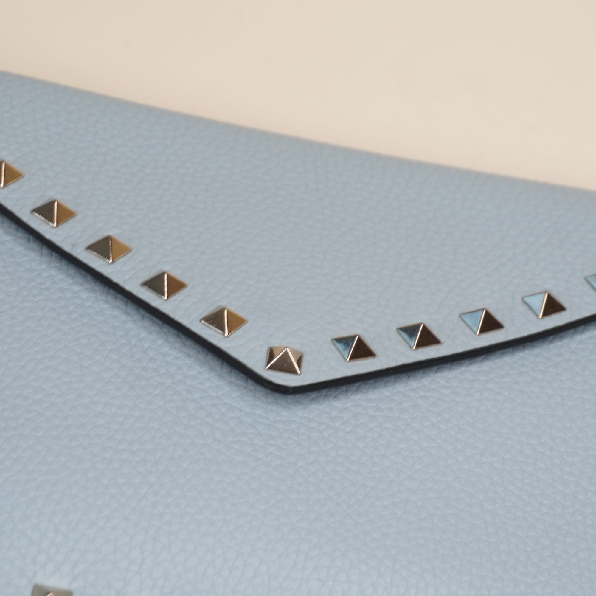 PRE-OWNED Light Blue Rockstud Grainy Calfskin Pouch