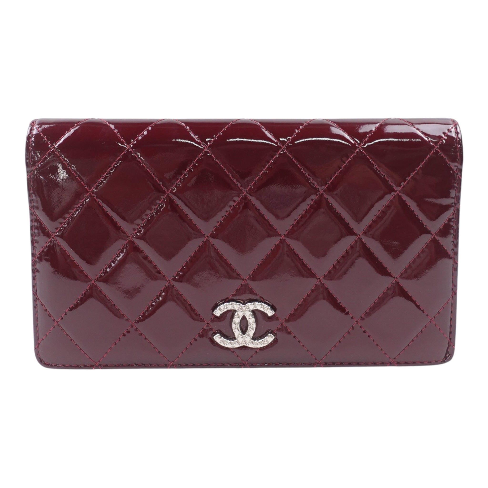 Cartera CC acolchada con yenes brillantes en color burdeos de charol, de segunda mano